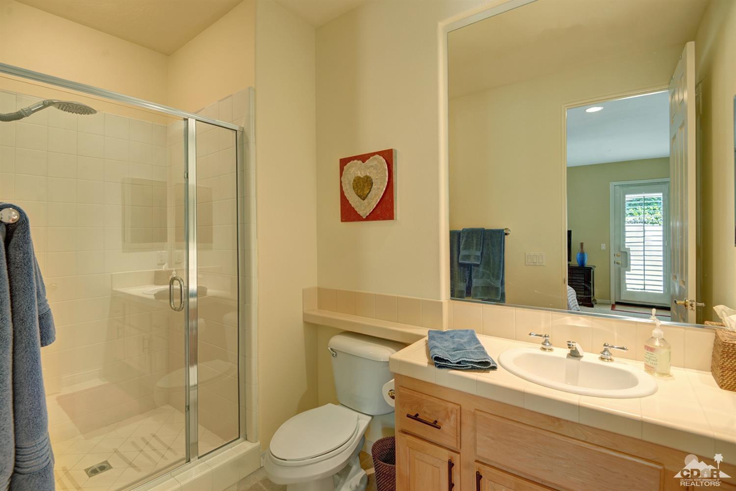 79675 Cetrino La Quinta, CA 92253 - Photo 23 of 34 a bathroom with a granite countertop sink toilet mirror and shower