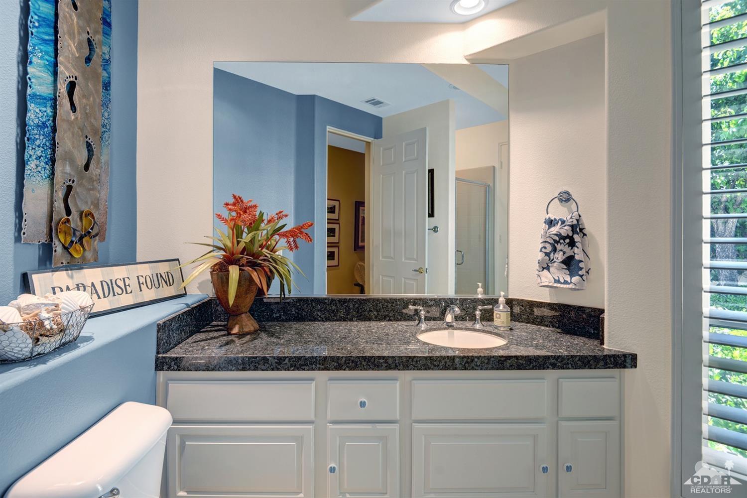 79675 Cetrino La Quinta, CA 92253 - Photo 26 of 34 a bathroom with a granite countertop sink a mirror and a
