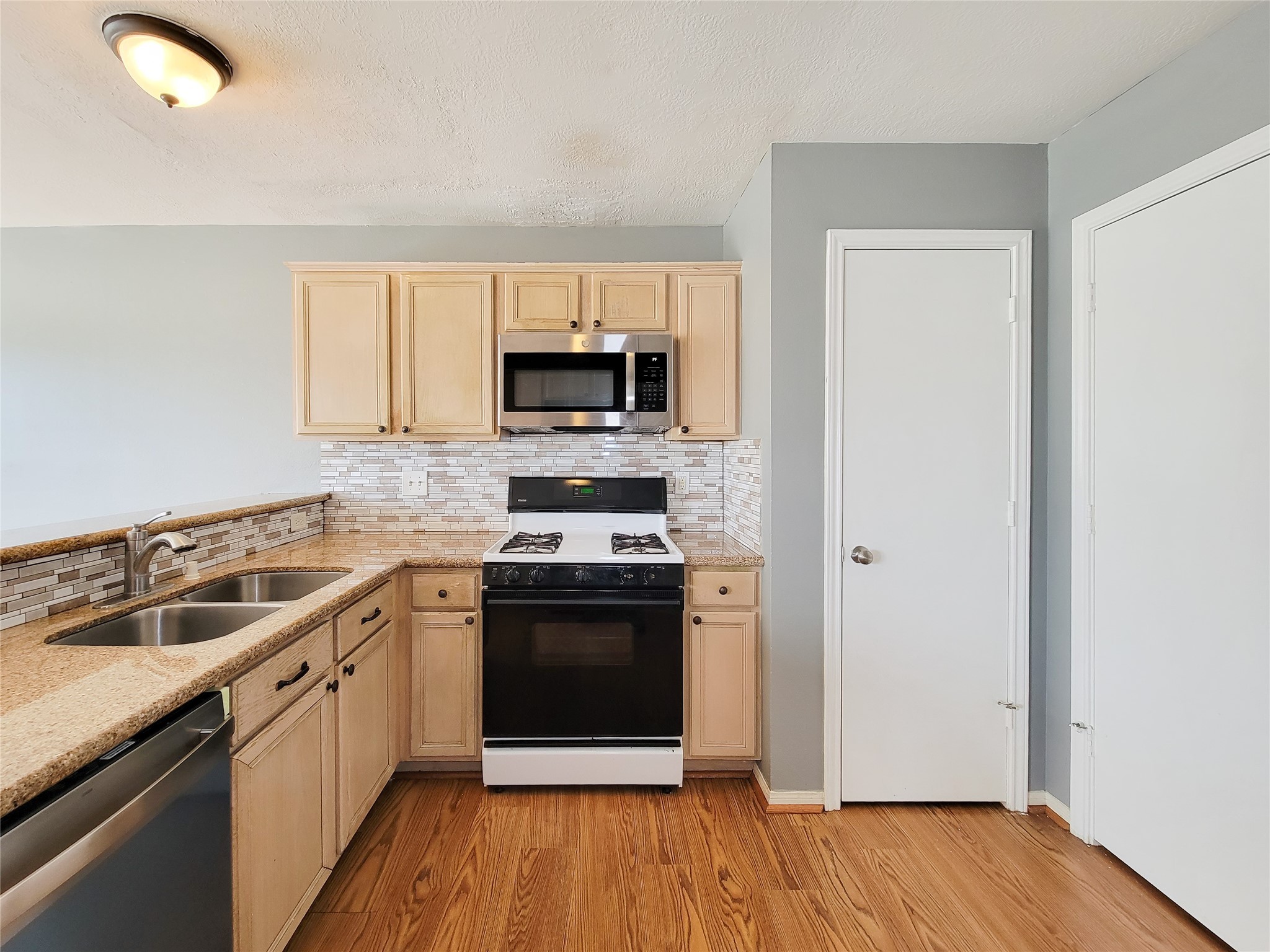 18335 Westlock Street Tomball, TX 77377 - Photo 12 of 38 a kitchen with a sink stove and microwave