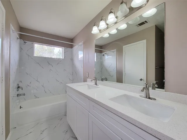 a bathroom with a sink a tub and a mirror
