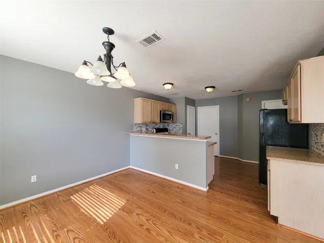 a view of a kitchen with wooden floor and a sink