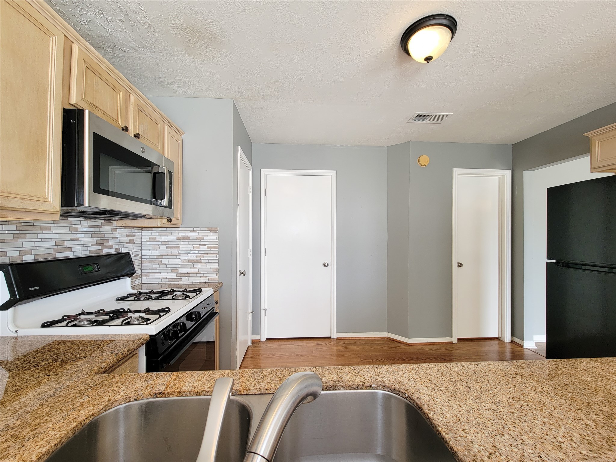 18335 Westlock Street Tomball, TX 77377 - Photo 10 of 38 a kitchen with kitchen island granite countertop a sink stainless steel appliances and cabinets