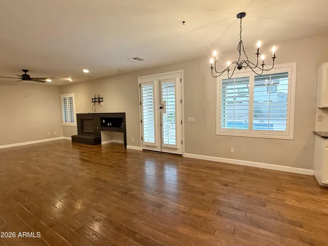 an empty room with a ceiling fan and window