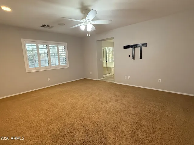 an empty room with a window and a ceiling fan
