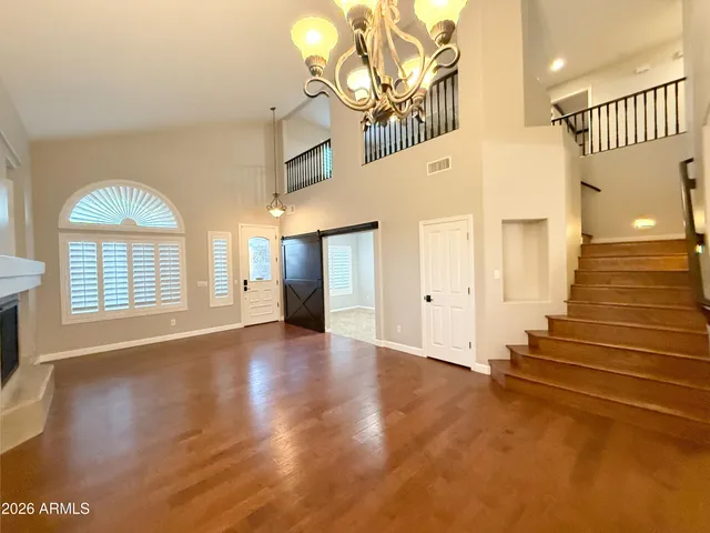 a kitchen with stainless steel appliances granite countertop a stove a sink a refrigerator and white cabinets with wooden floor