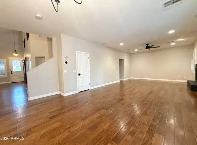 an empty room with windows and fan