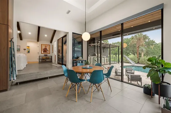 a dining room with furniture and large windows