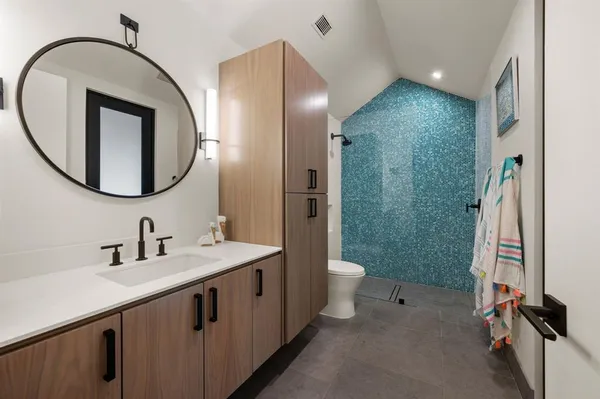 a bathroom with a sink a toilet and a mirror