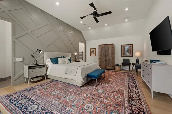 a bedroom with a bed a couch and a flat screen tv