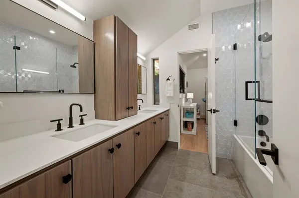 a large bathroom with a double vanity sink a large mirror and a shower