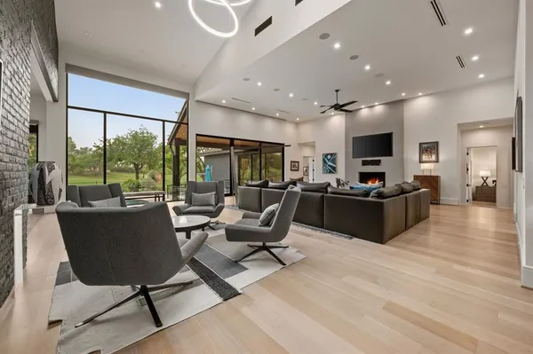 a living room with furniture a flat screen tv and a large window