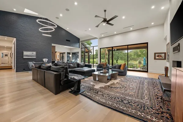 a living room with furniture large window and flat screen tv