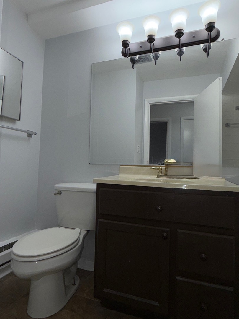 1110 18th Street, Unit GE Broadview, IL 60155 - Photo 11 of 20 a bathroom with a toilet a sink and mirror