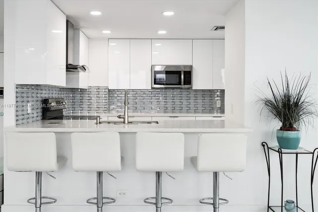 a kitchen with stainless steel appliances kitchen island sink refrigerator and stove