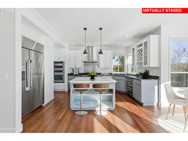 a living room with stainless steel appliances kitchen island granite countertop furniture and a wooden floor