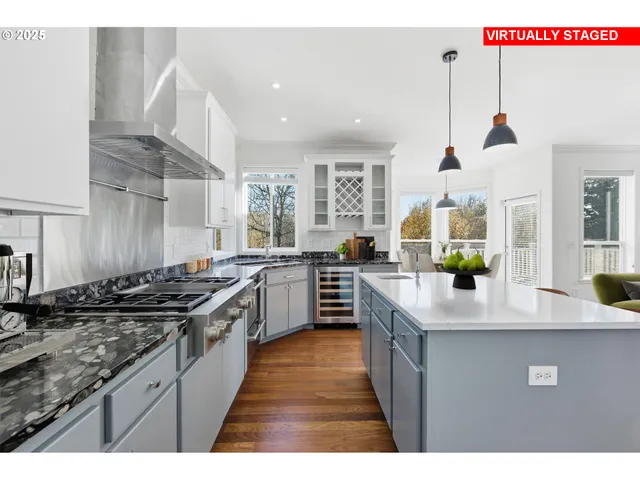 a kitchen with stainless steel appliances granite countertop a sink a stove and a wooden floors
