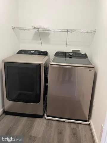 a utility room with wooden floor washer and dryer
