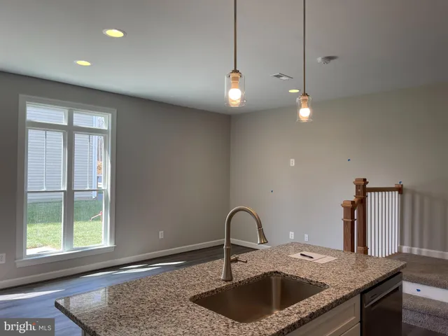 a kitchen with kitchen island a sink stainless steel appliances and a window
