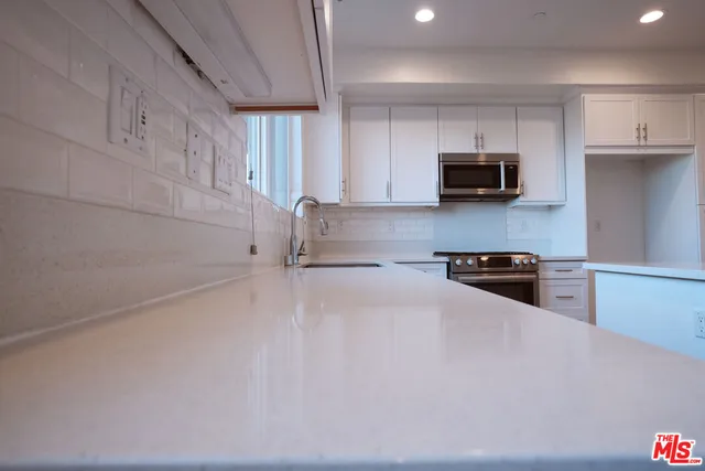 a kitchen with stainless steel appliances a stove a microwave a sink and cabinets