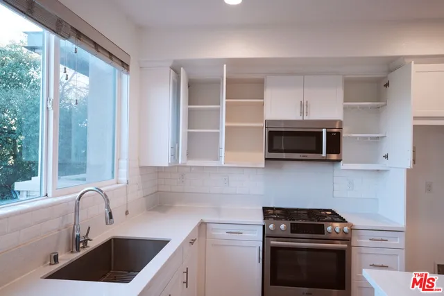 a kitchen with a sink stove top oven and cabinets