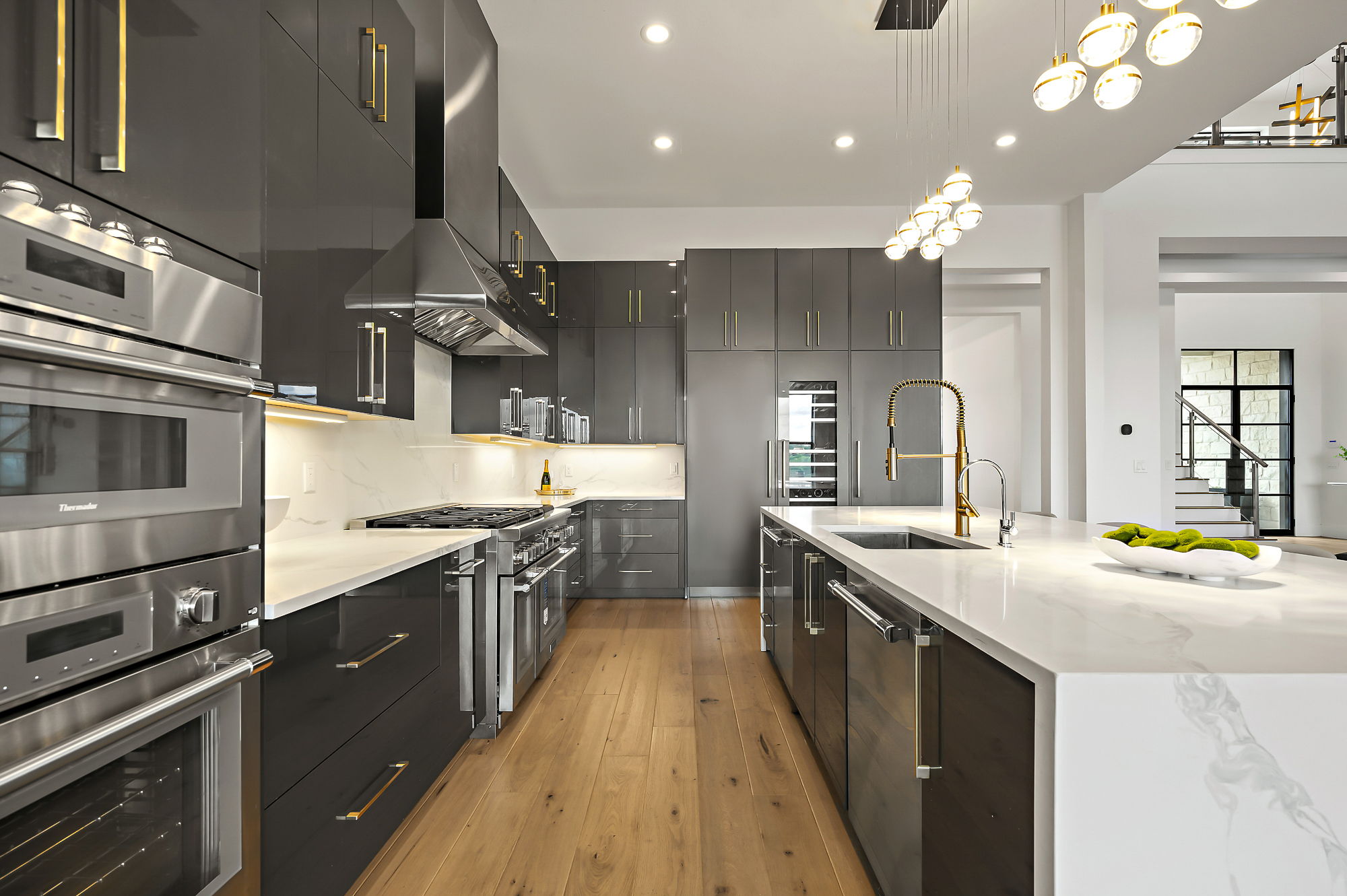 10211 Thistle Ridge Austin, TX 78733 - Photo 13 of 39 a kitchen with stainless steel appliances granite countertop a sink a stove and a wooden floors