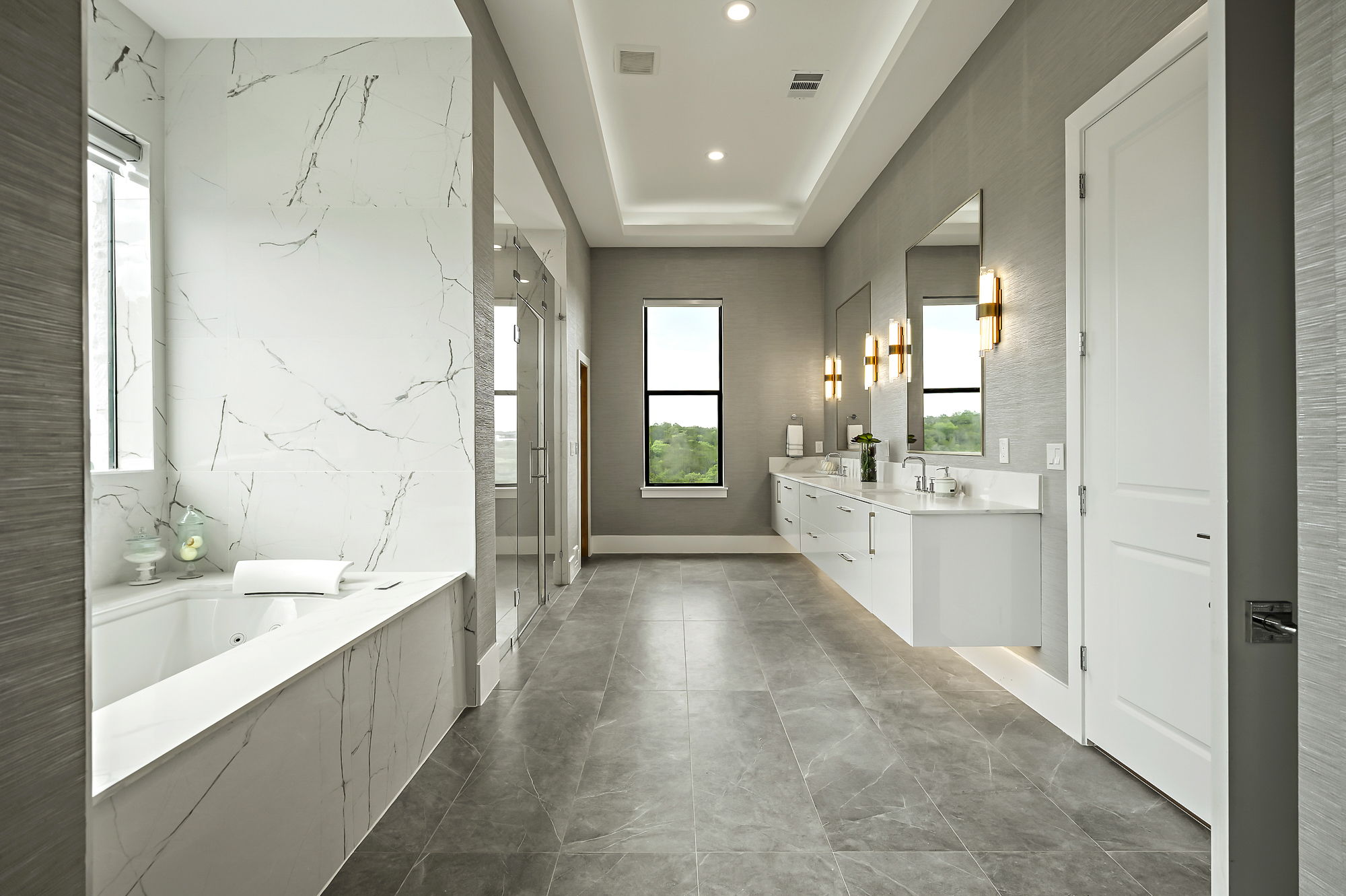10211 Thistle Ridge Austin, TX 78733 - Photo 19 of 39 a large white bathroom with a large mirror vanity and shower