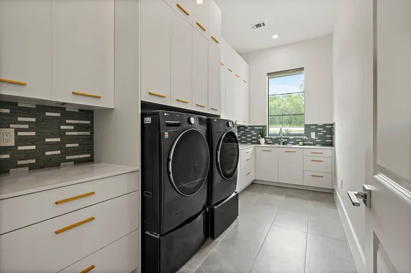 a utility room with cabinets washer and dryer