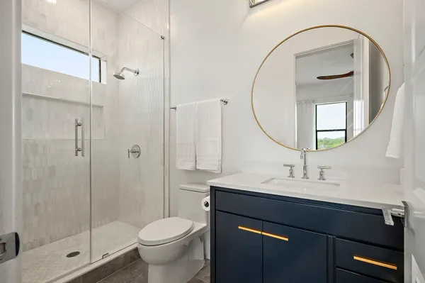 a bathroom with a sink a toilet and shower