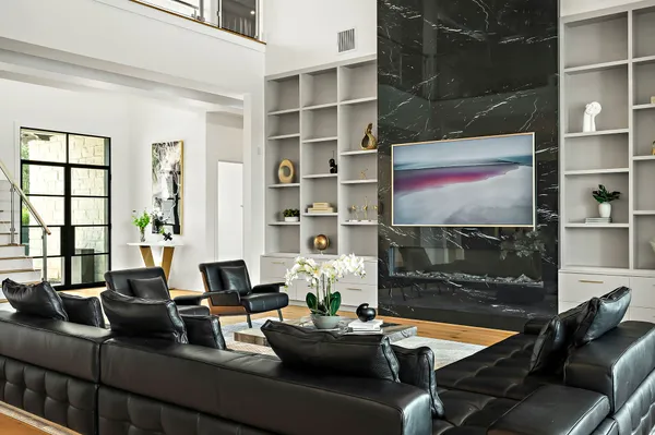 a living room with furniture a flat screen tv and a floor to ceiling window
