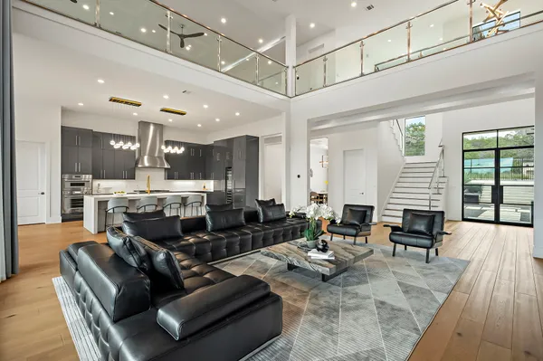 a living room with furniture kitchen view and a large window