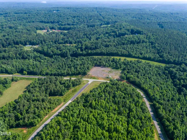 an aerial view of a house with a yard and lake view