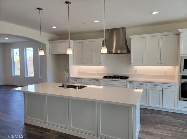 a kitchen with stainless steel appliances granite countertop a sink a refrigerator and a stove