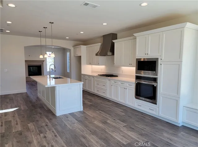 a large kitchen with stainless steel appliances granite countertop a large counter top and a stove