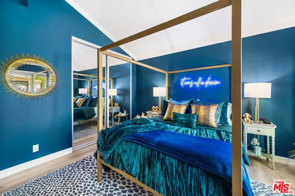 a bedroom with a bed and a lamp on dresser