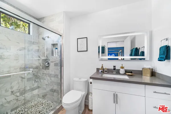 a bathroom with a sink a toilet and shower