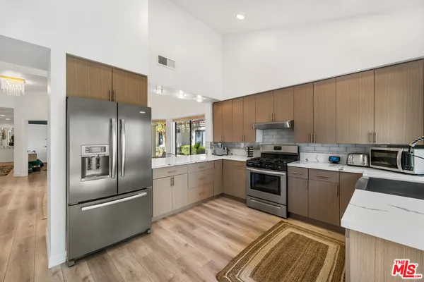 a kitchen with a refrigerator sink and stainless steel appliances