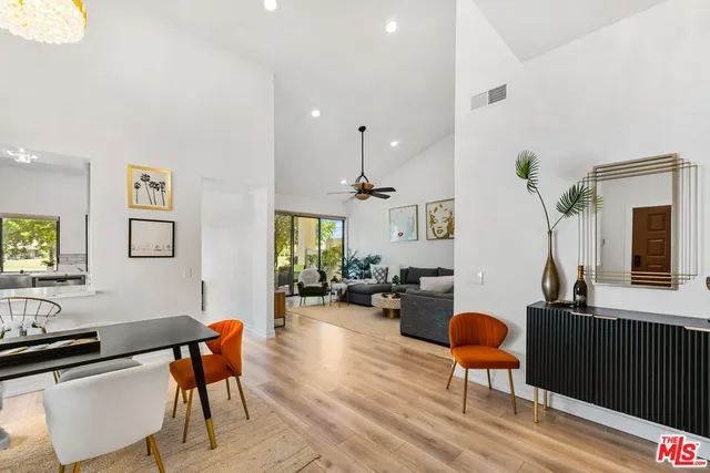 a living room with furniture a flat screen tv and a table
