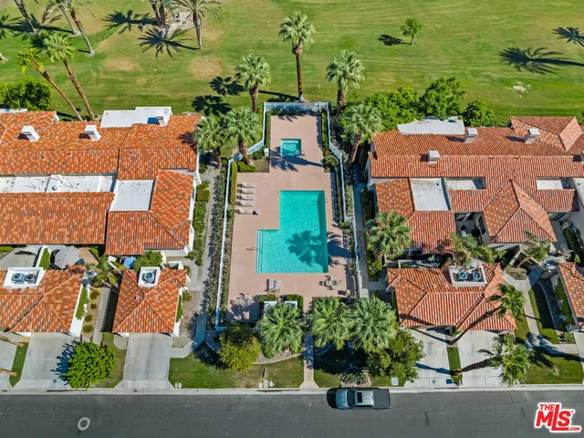 an aerial view of residential houses with outdoor space and parking