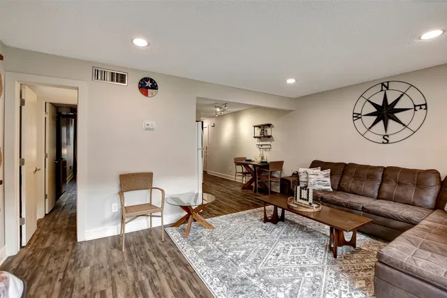 a living room with furniture and a wooden floor