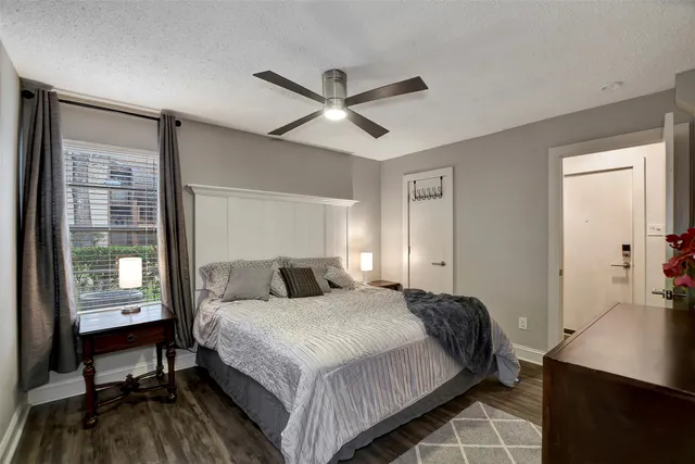 a bedroom with a bed a desk and chair with a large mirror