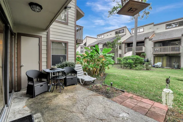 a view of a patio with table and chairs and potted plants