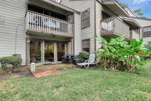 a view of a house with backyard and sitting area