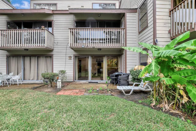 a view of a house with a patio and a yard