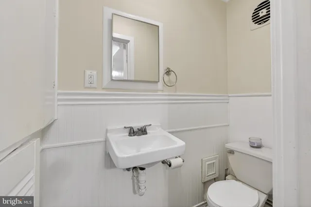 a bathroom with a sink a toilet and mirror