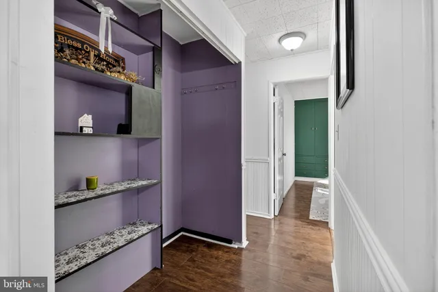 a view of an empty room with wooden floor and closet