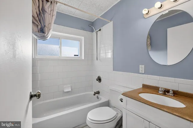 a bathroom with a toilet a sink a mirror and bathtub