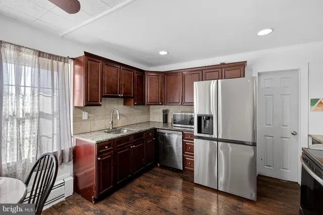a kitchen with granite countertop wooden cabinets a refrigerator and a sink