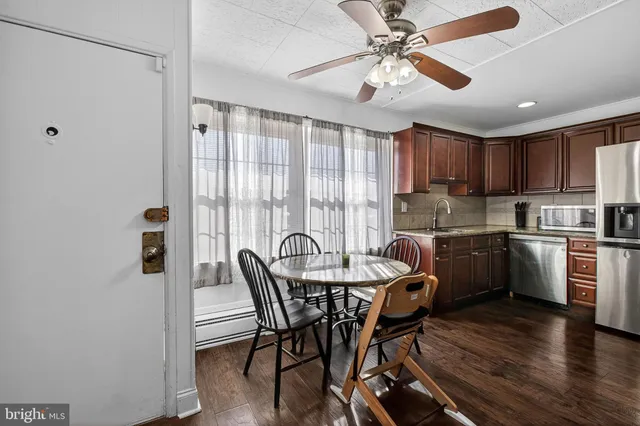 a kitchen with a table chairs stainless steel appliances and cabinets