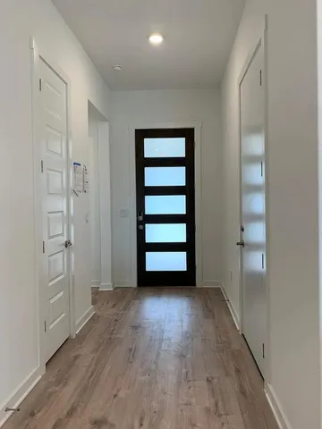 an empty room with wooden floor closet and windows