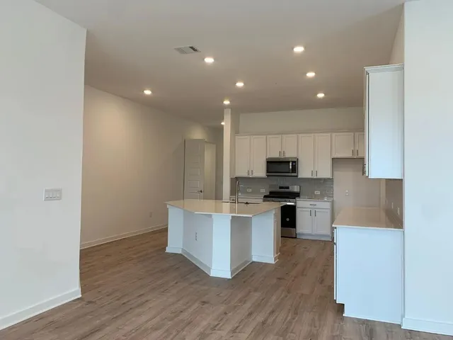 a kitchen with kitchen island granite countertop a stove top oven and cabinets